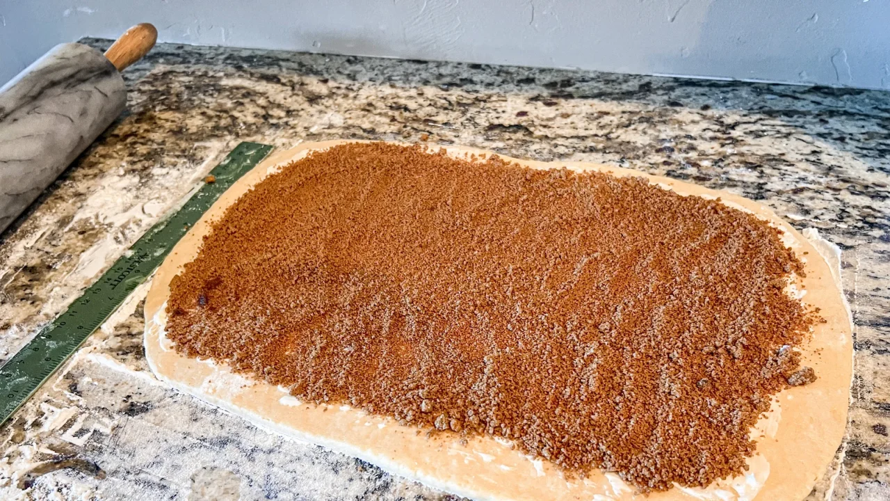 cinnamon rolls rolled out with cinnamon on top before baking