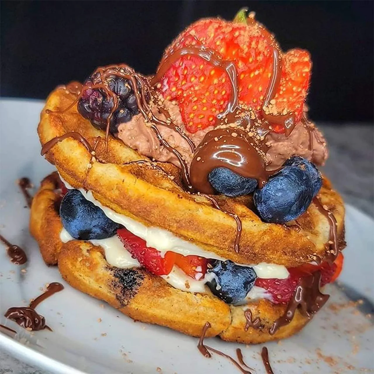 strawberries and blueberries and Buttery Cinnamon Roll Seasoning on a waffle like sandwich