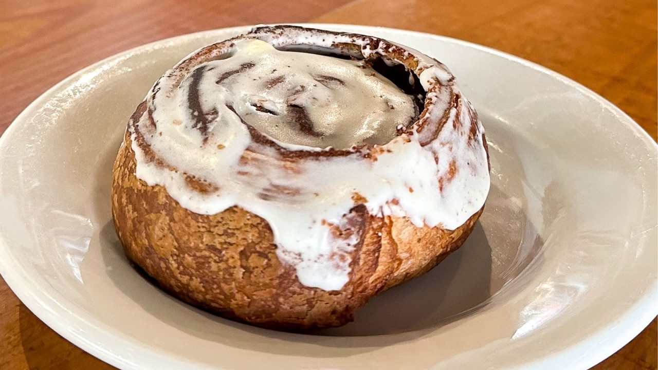 a brioche cinnamon bun on a white plate