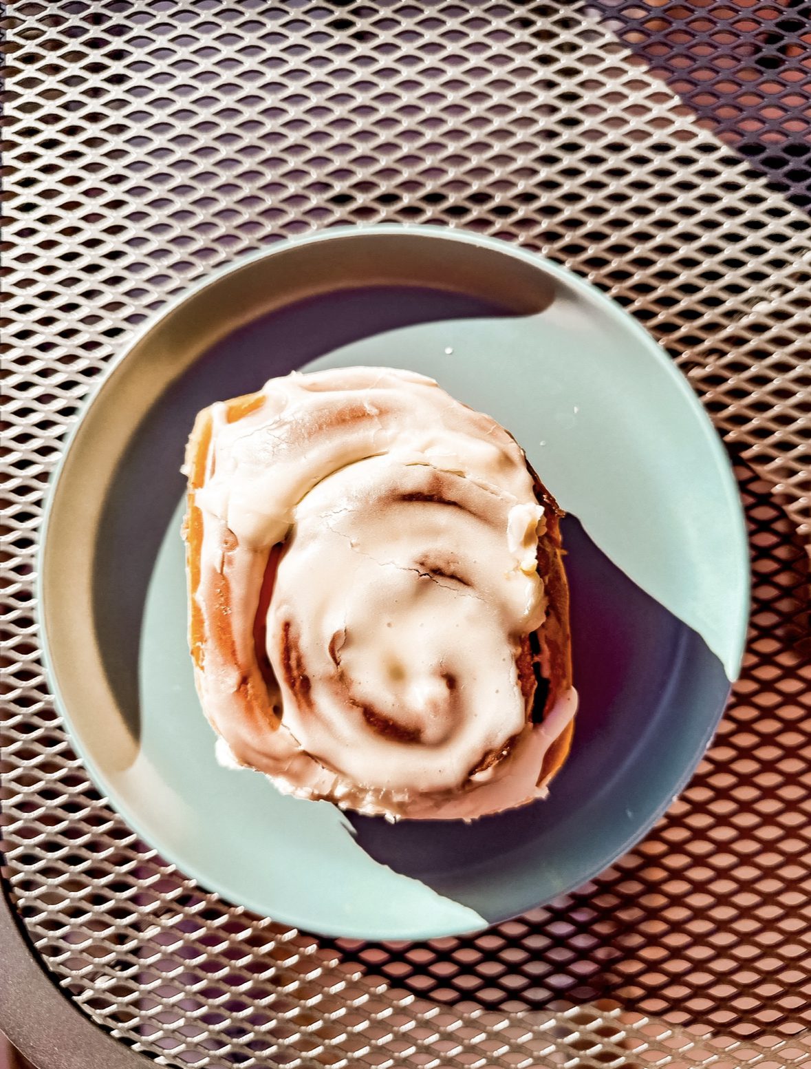 a cinnamon roll on a blue plate